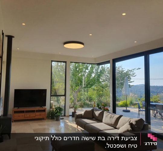 סלון מודרני עם ספה, טלוויזיה וחלונות גדולים